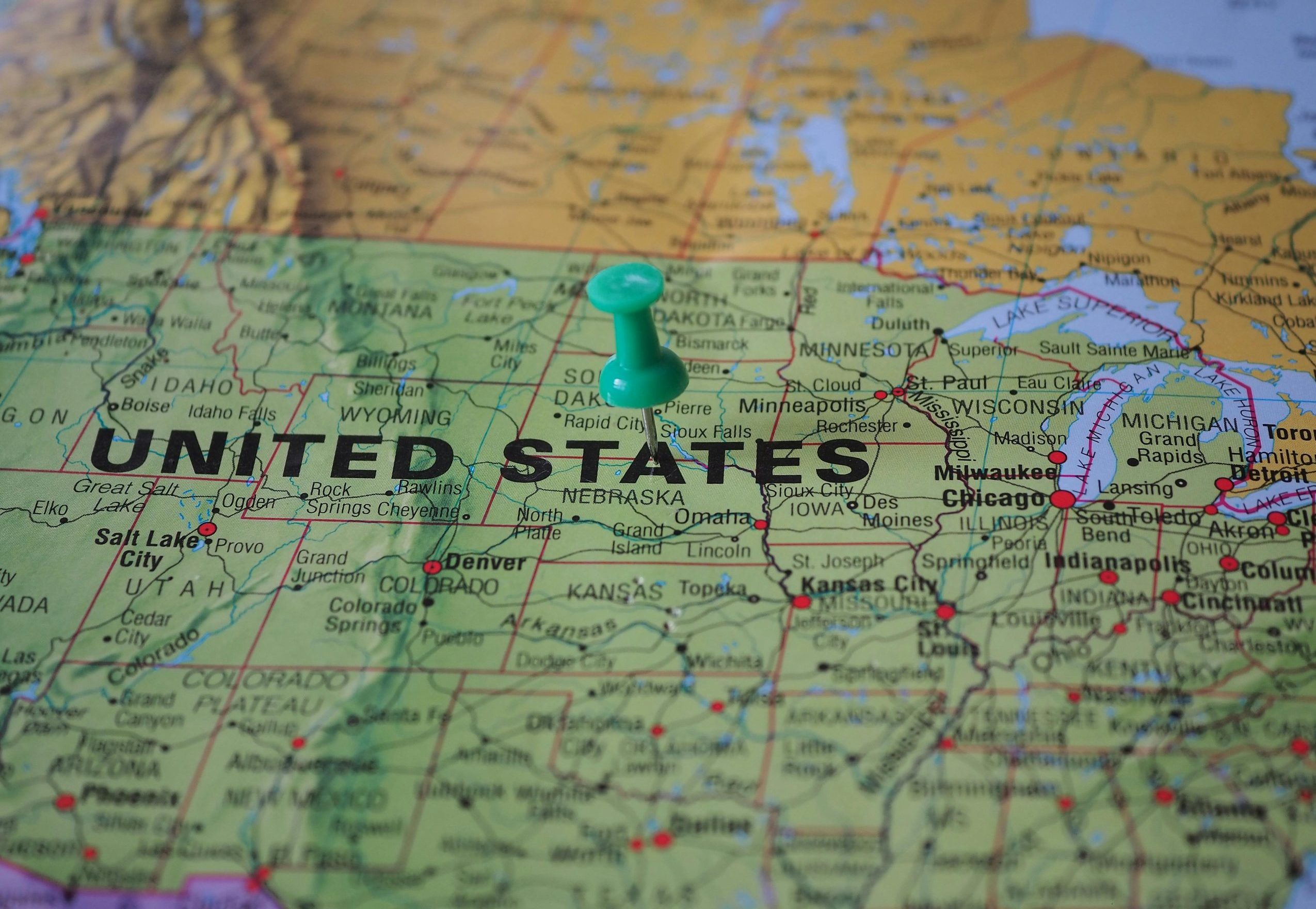 High-angle view of a map featuring the United States with a green pin indicating a specific location.